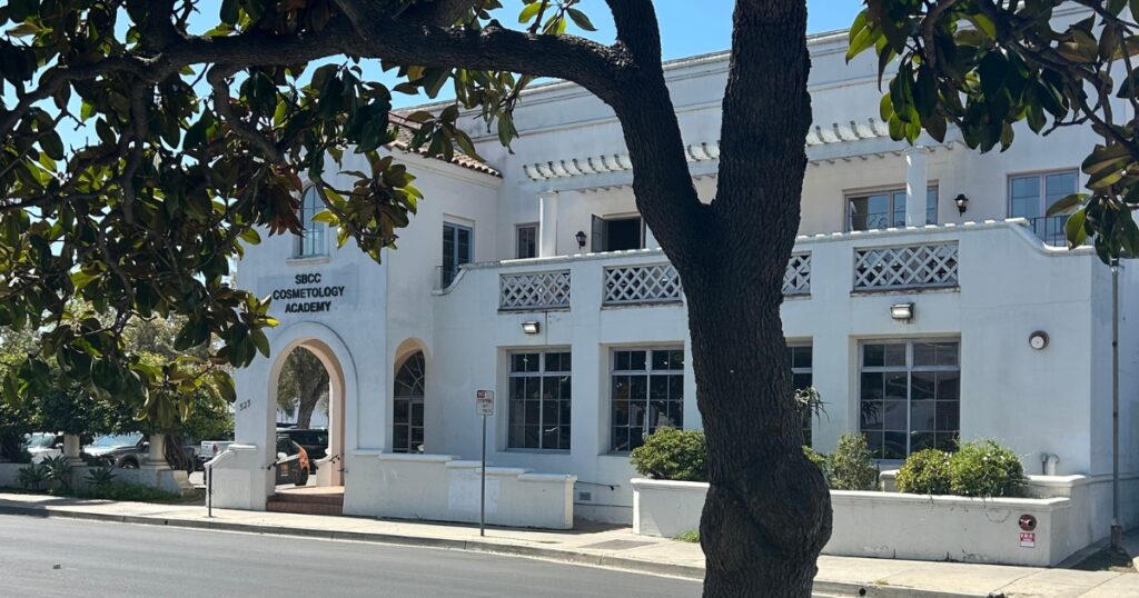 Street view of a white, two story building in Downtown Santa Barbara, CA. SBCC Cosmetology Academy is written over the front entrance. Santa Barbara City College esthetician program -- an esthetician community college program in Southern California.