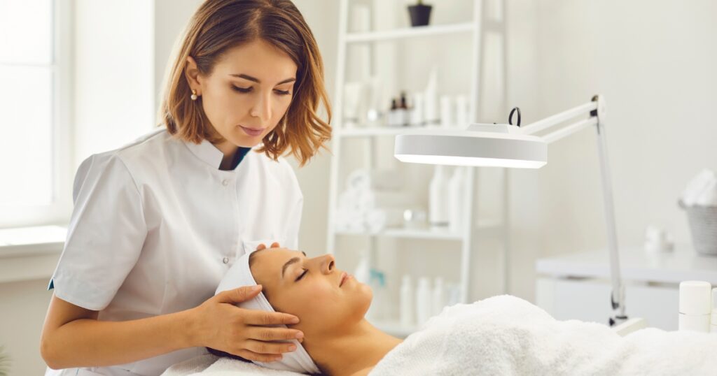 Esthetician performing a skin analysis on a client before a treatment. 